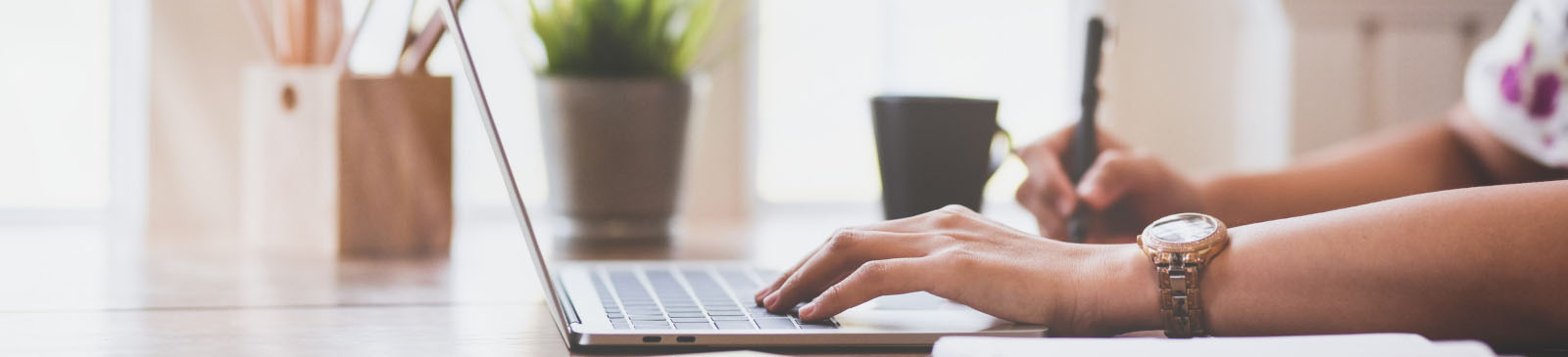 Sideview of young woman working on her laptop computer